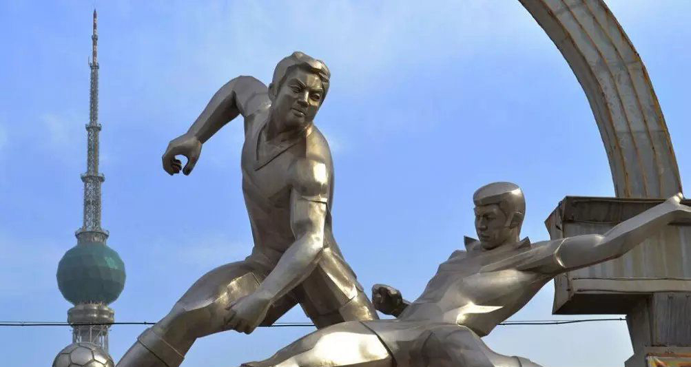 公园不锈钢踢足球的人物雕塑图片